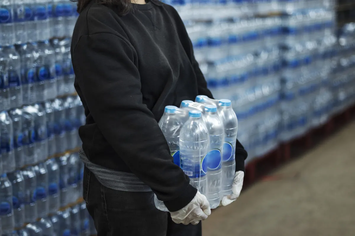 Mulher realizando a compra de água mineral em grande quantidade.